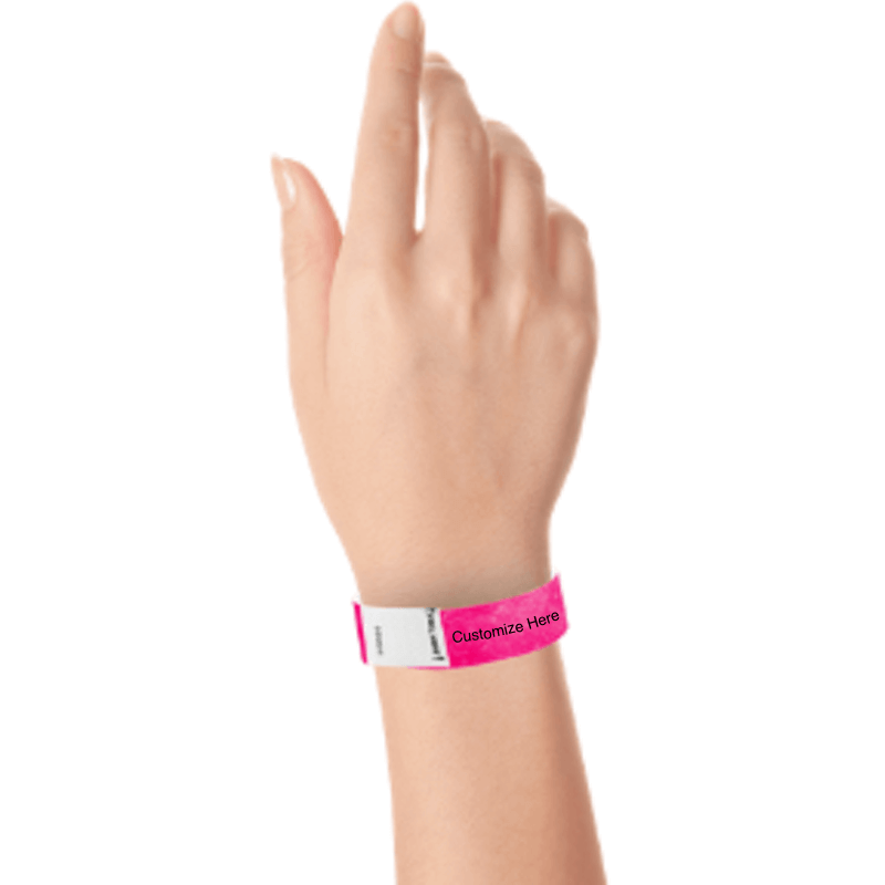 hand wearing a neon pink tyvek 3/4" litter free wristband with a placeholder for customizing with your text or logo