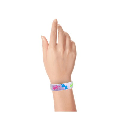 hand wearing a berry tyvek wristband with a gecko pattern in neon green, neon pink and neon blue