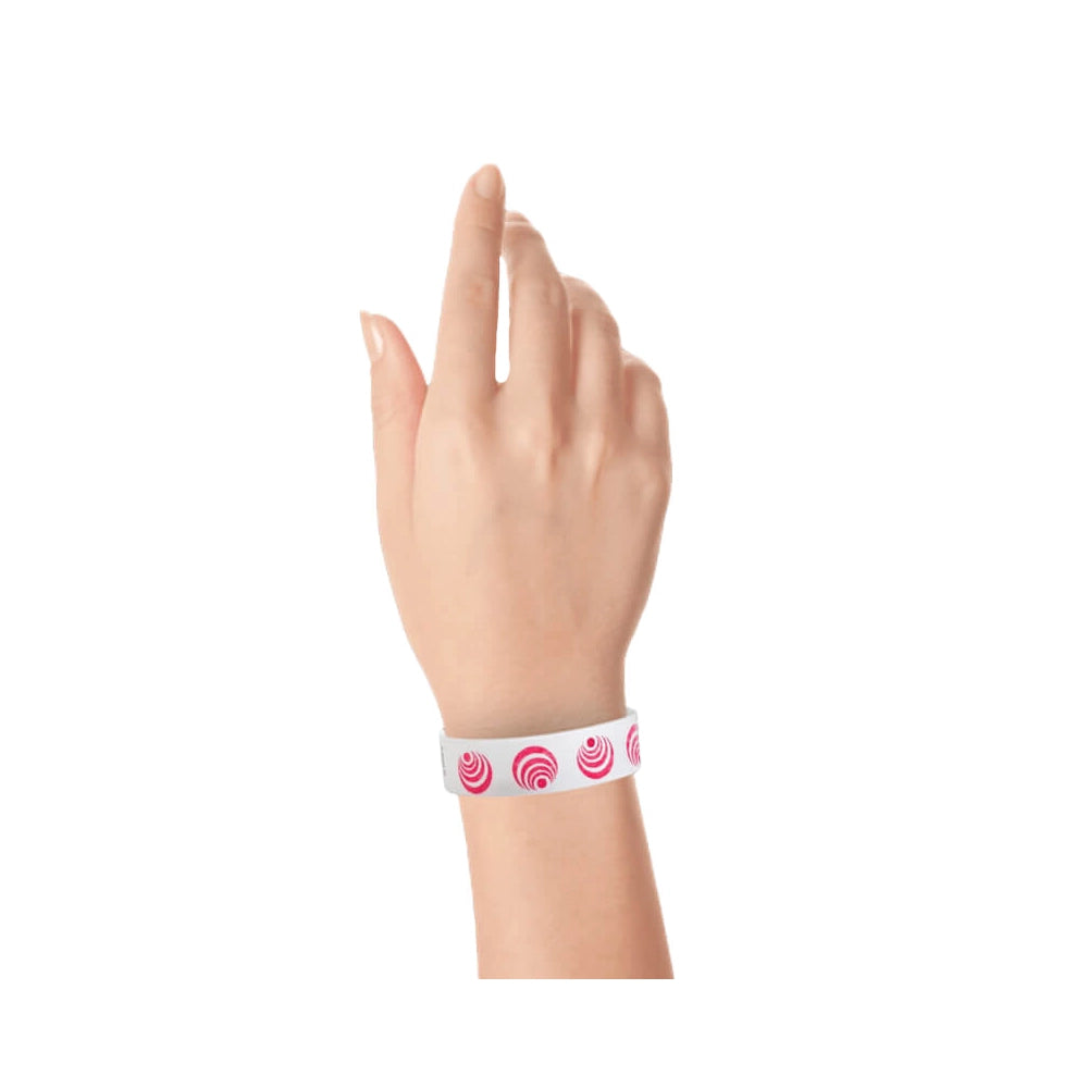 wrist wearing a white tyvek wristband with neon red circle patterns spinning