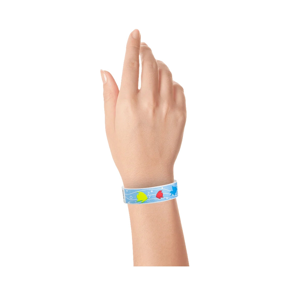 wrist showing a sky blue tyvek wristband with a tropical fish pattern under water in neon blue, neon red, neon yellow and white
