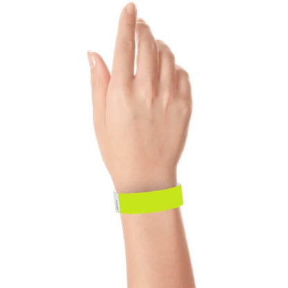 hand wearing a 3/4" tyvek wristband solid lime green