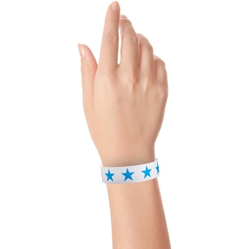Hand wearing a white tyvek wristband with neon blue stars 