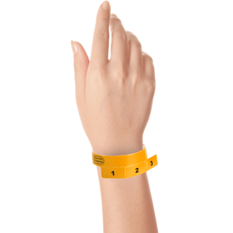 vinyl 3 tab wristbands shown in stock pattern with imprint "stub void if detached" and the number 1-3 on the stubs in neon orange on hand 
