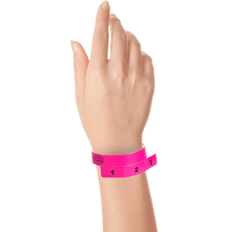 vinyl 3 tab wristbands shown in stock pattern with imprint "stub void if detached" and the number 1-3 on the stubs in neon pink on hand 