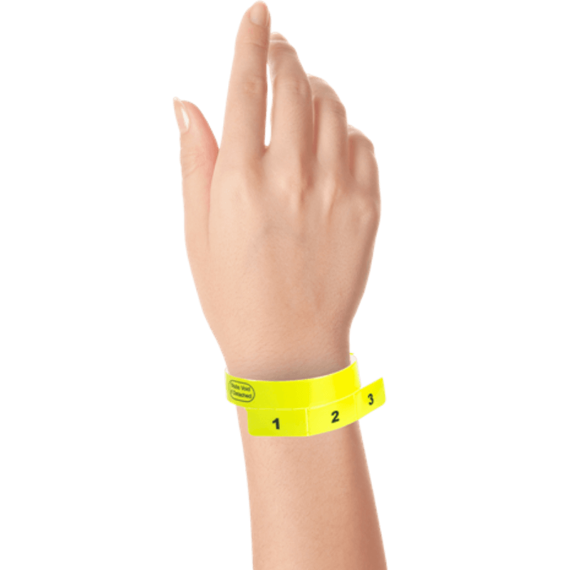 vinyl 3 tab wristbands shown in stock pattern with imprint "stub void if detached" and the number 1-3 on the stubs in neon yellow on hand 