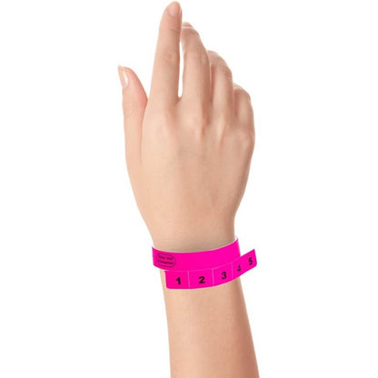 vinyl 5 tab wristbands shown in stock pattern with imprint "stub void if detached" and the number 1-5 on the stubs, shown on hand in neon pink