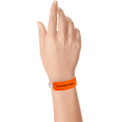 Hand wearing wide face vinyl wristbands with a placeholder to show where you can customize the wristband in neon orange