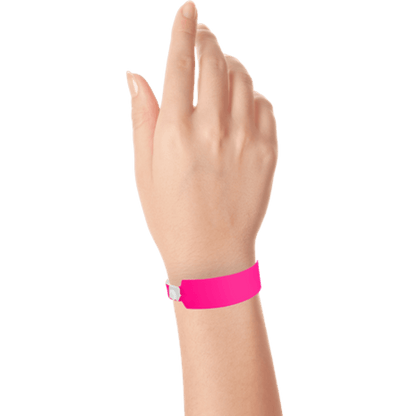Wide face vinyl solid wristbands on hand in neon pink