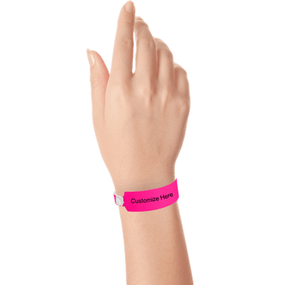 Hand wearing wide face vinyl wristbands with a placeholder to show where you can customize the wristband in neon pink