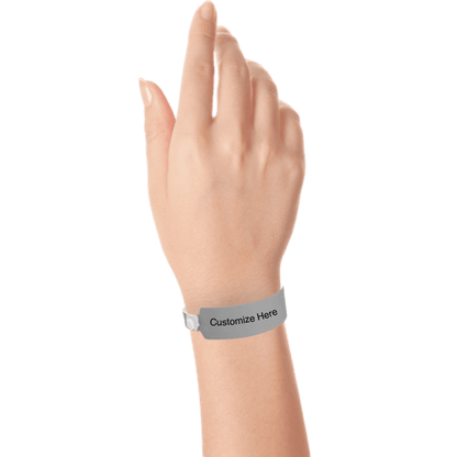 Hand wearing wide face vinyl wristbands with a placeholder to show where you can customize the wristband in silver