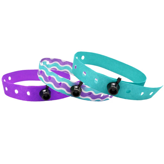 snap closure cloth wristbands shown in purple, teal and a purple,teal and white pattern
